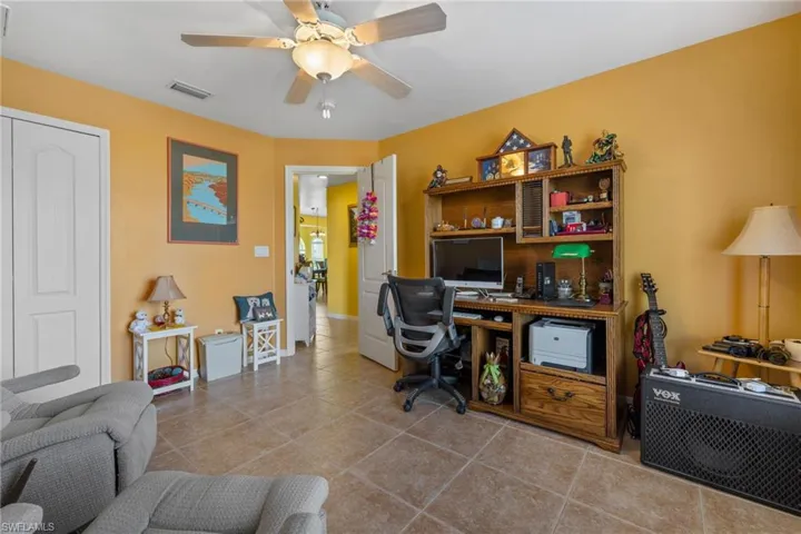 Home office featuring light tile patterned floors and ceiling fan