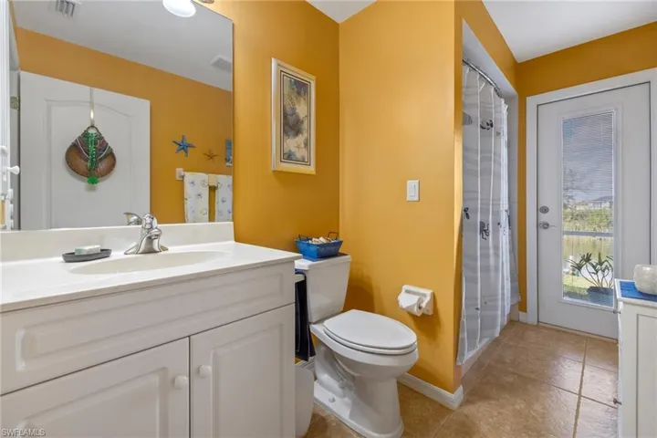 Bathroom with a shower with curtain, vanity, and toilet