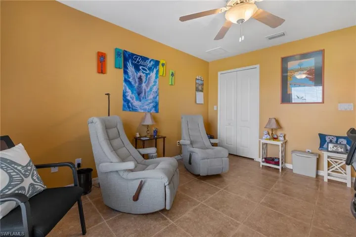Living area featuring ceiling fan and tile patterned flooring