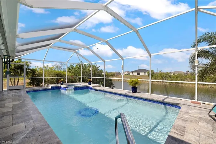 View of pool featuring a water view, an in ground hot tub, a lanai, and a patio area