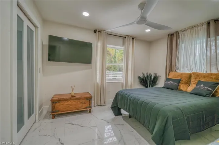 Bedroom with baseboards, recessed lighting, marble finish flooring, and a ceiling fan