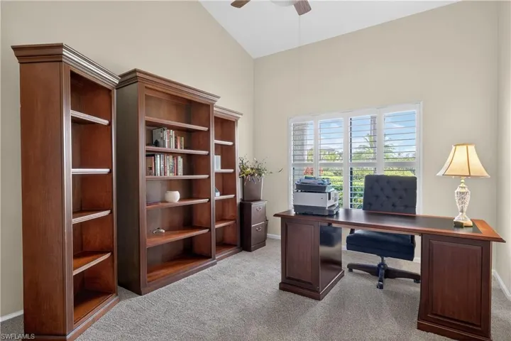 Office featuring light colored carpet, lofted ceiling, and ceiling fan