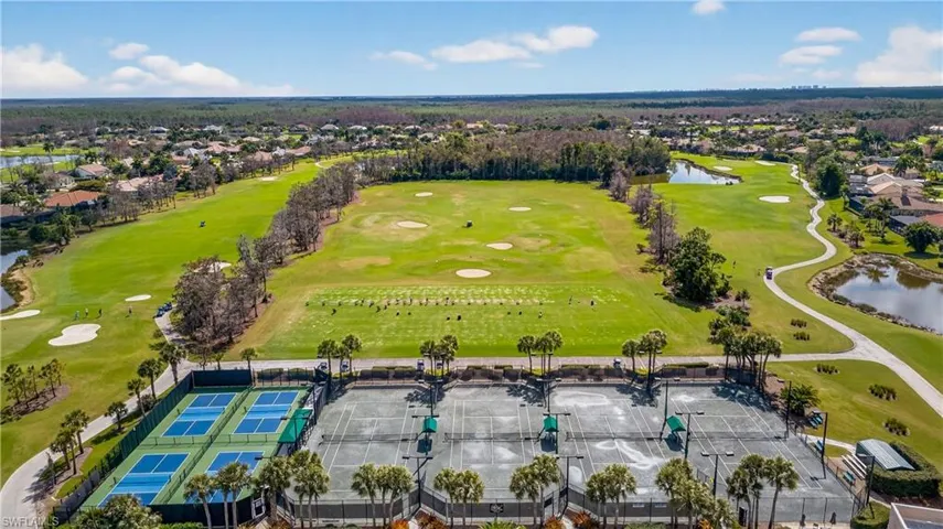 Aerial view of residential area featuring a nearby body of water and a golf club