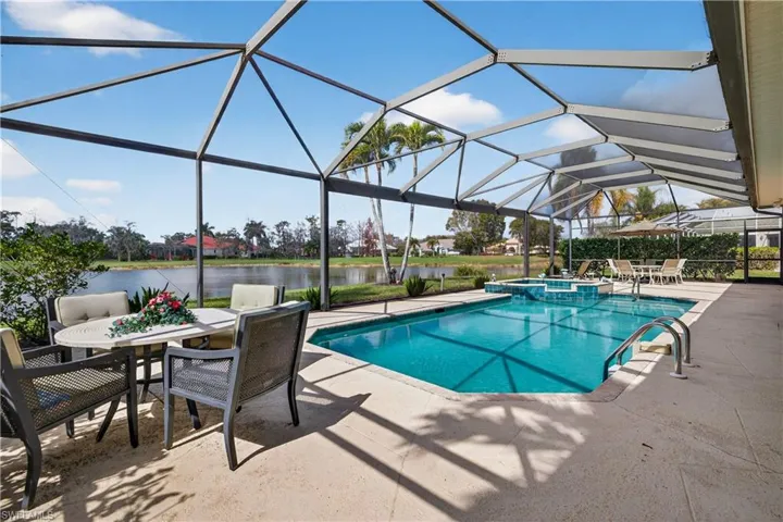 Combined pool / hot tub featuring outdoor dining space, a patio, a sunroom, a lanai, and a water view
