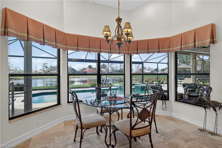 Dining room featuring a chandelier, stone tile floors, and a water view