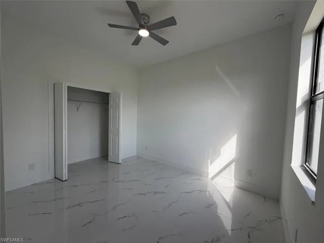 Interior space featuring white walls and a ceiling fan with integrated lighting