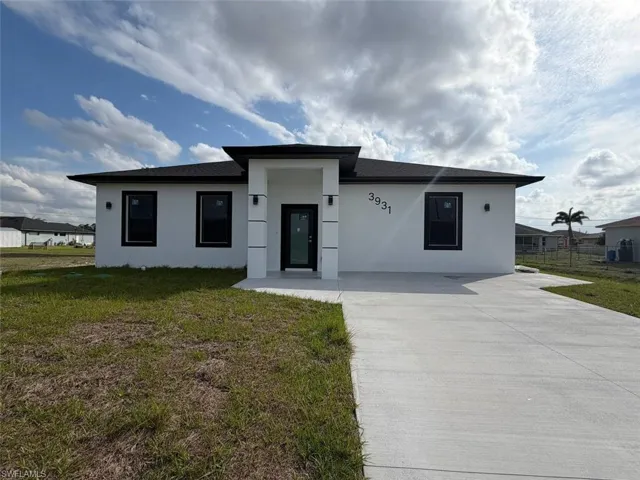 Contemporary single-story residence featuring a white stucco exterior and black framed windows