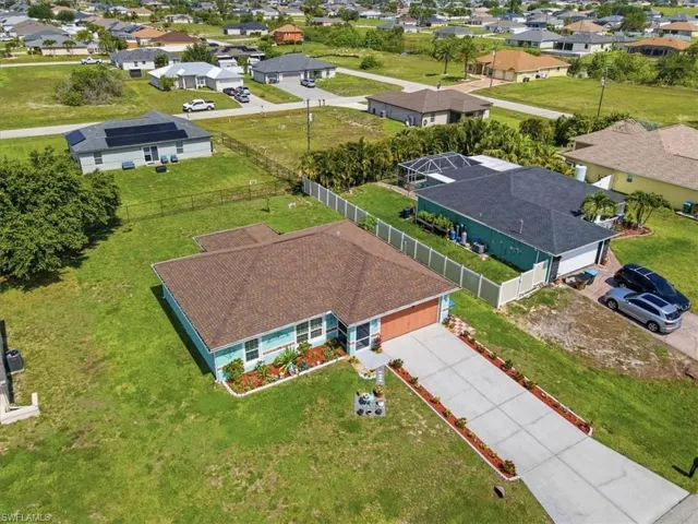 Single-story home featuring a teal exterior and a brown shingle roof