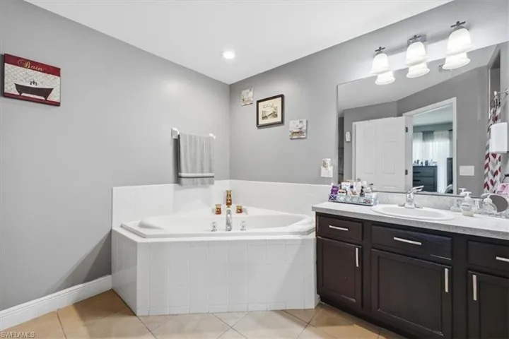 Corner soaking tub with white tile surround