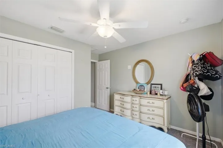Recessed ceiling light with a white ceiling fan, white bi-fold closet doors, and light gray wall paint
