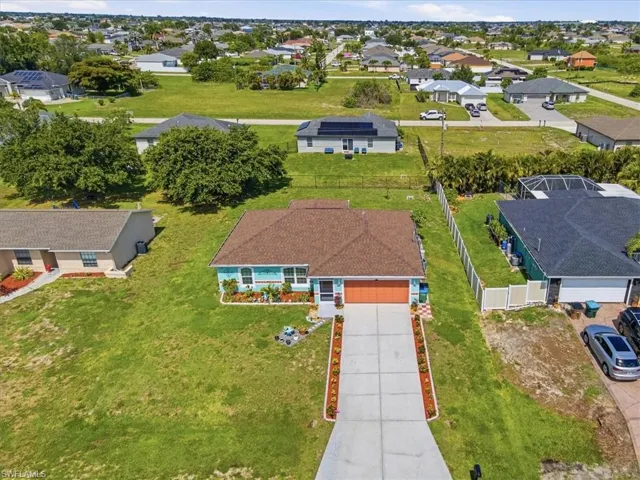 Single-story residence with a brown shingle roof, light blue siding, and an orange garage door