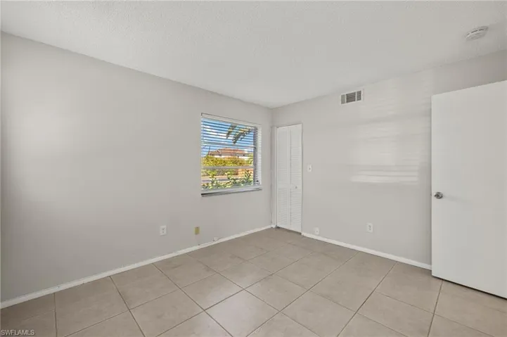 Unfurnished room with light tile patterned flooring, baseboards, visible vents, and a textured ceiling