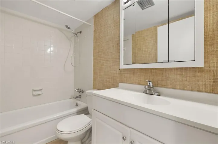 Full bath with vanity, toilet, washtub / shower combination, and visible vents