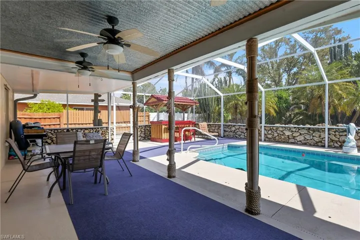 View of swimming pool featuring patio surround, a lanai, outdoor dining space, a sunroom, and a fenced backyard