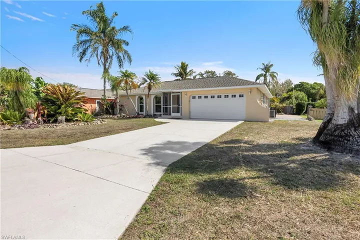 Ranch-style home with stucco siding, a garage, and driveway