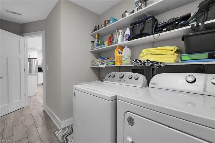 Laundry room featuring wood tiled floors and washer and clothes dryer