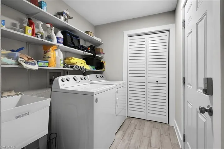 Laundry room featuring wood tiled floors and washing machine and dryer