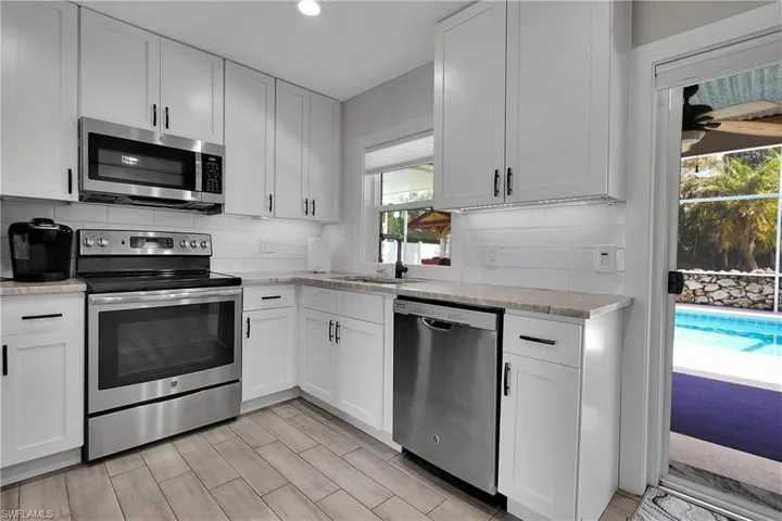 Kitchen featuring stainless steel appliances, white cabinets, tasteful backsplash, and recessed lighting