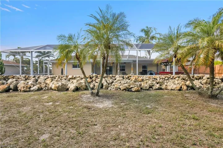 Back of house featuring a lanai, a yard, and a sunroom