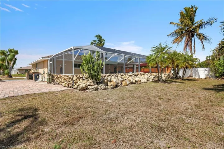 Back of house featuring a sunroom, a lanai, and a patio area
