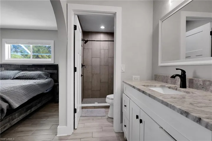 Bathroom with vanity, a stall shower, and wood tiled floors