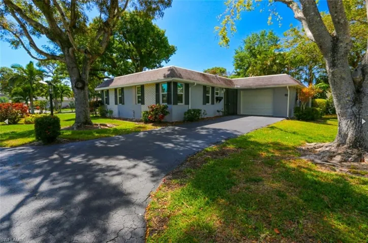 Ranch-style house with a garage and a front lawn