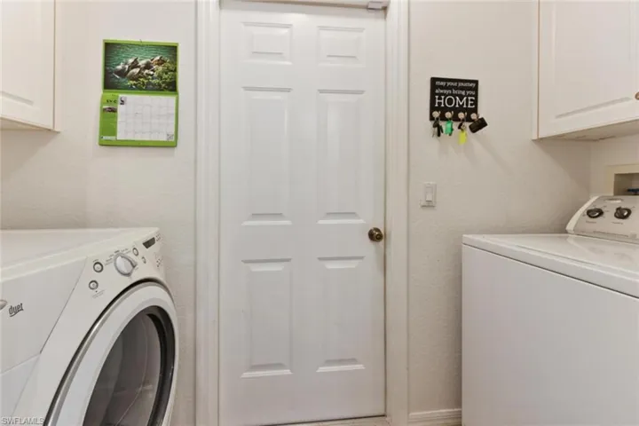 Clothes washing area featuring hookup for a washing machine, separate washer and dryer, and cabinets