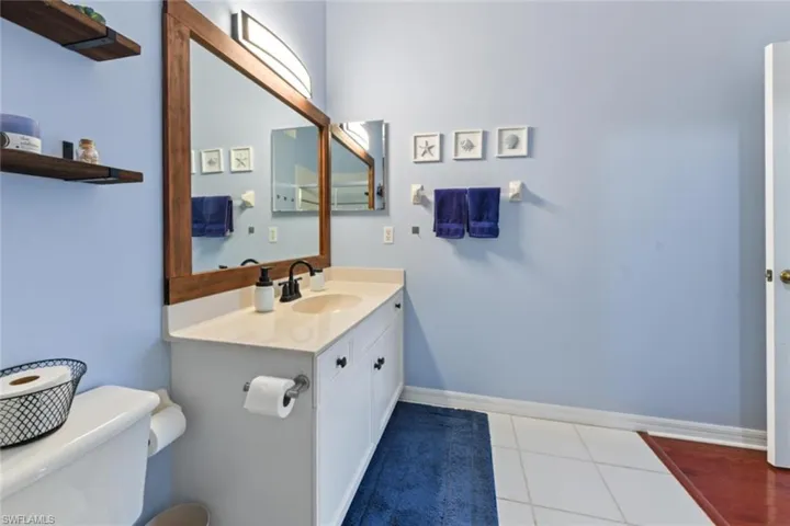 Bathroom featuring tile flooring, toilet, and large vanity