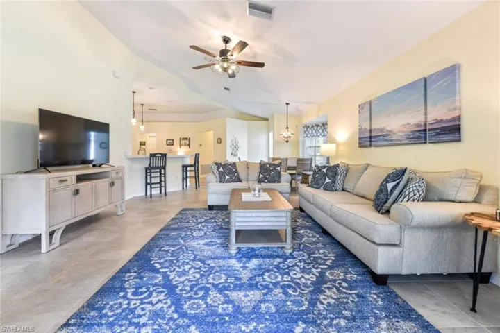 Living room featuring tile floors and ceiling fan