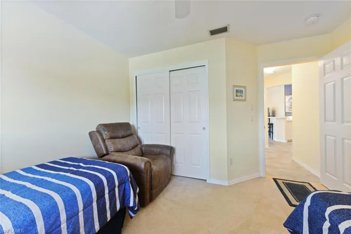 Bedroom with light carpet, a closet, and ceiling fan