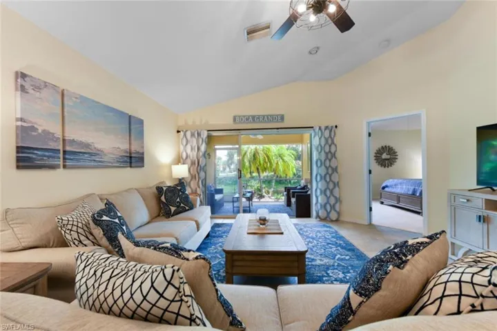 Living room featuring ceiling fan and lofted ceiling