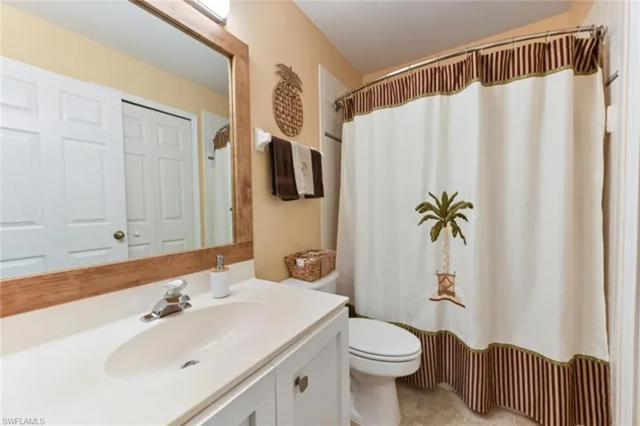 Bathroom with vanity with extensive cabinet space, tile flooring, and toilet