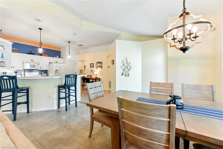 Dining space with light tile floors and an inviting chandelier