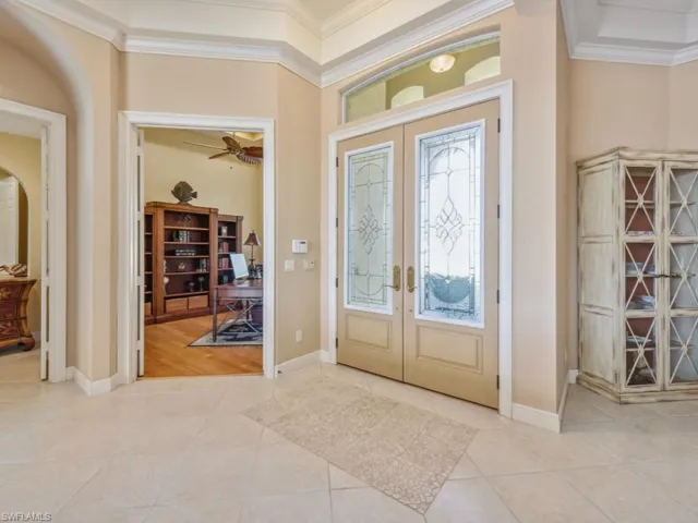 Entryway with crown molding, french doors, and light tile patterned floors