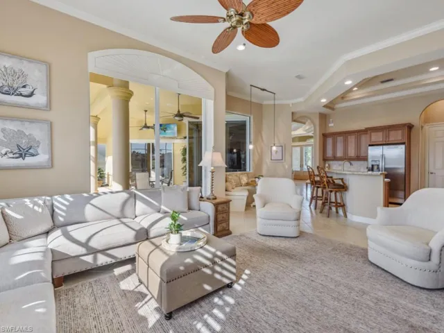Living room with arched walkways, recessed lighting, ornamental molding, and ceiling fan