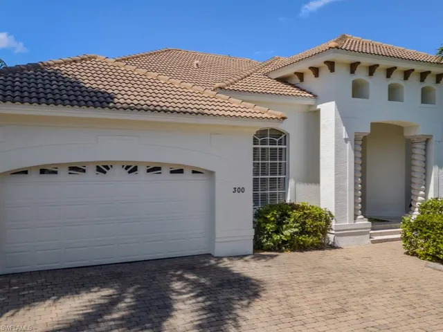 View of front of home with a tiled roof, a garage, stucco siding, and driveway