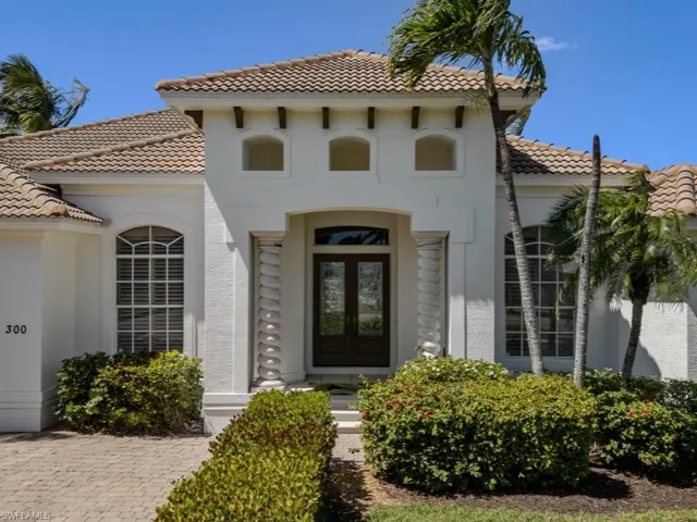 View of exterior entry with french doors, a tile roof, and stucco siding