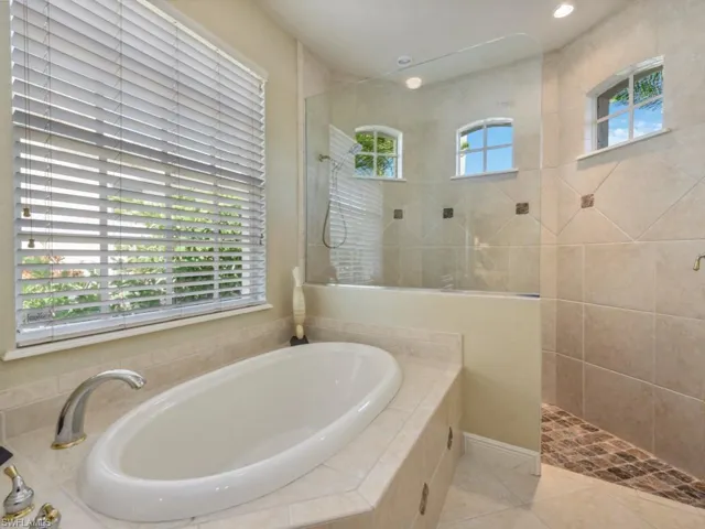 Full bath featuring tile patterned floors, walk in shower, and a garden tub