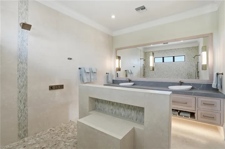 Bathroom featuring a walk in shower, ornamental molding, and vanity - Virtually Edited Image