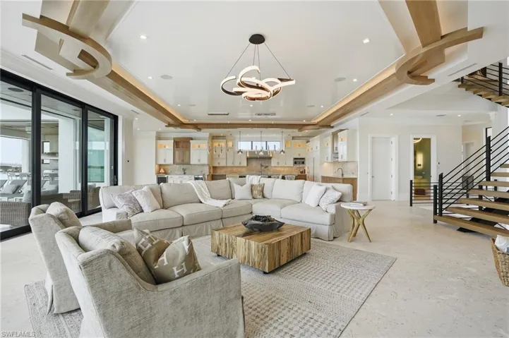 Living room featuring a tray ceiling and a chandelier - Virtually Edited Image