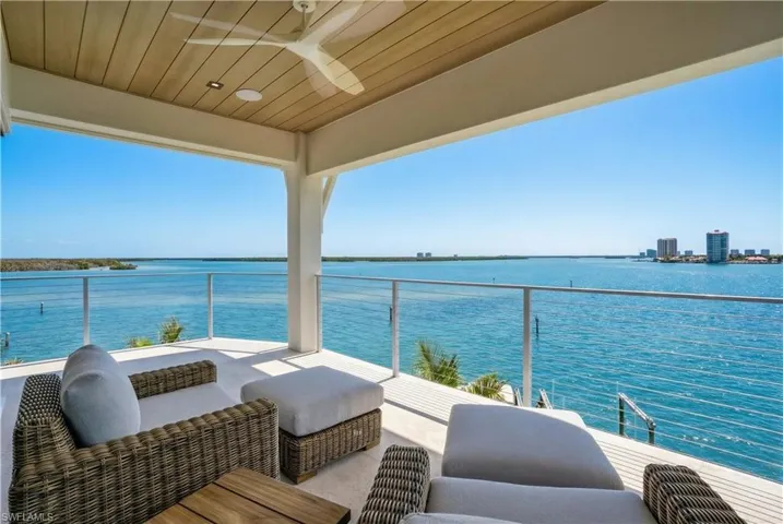 Balcony with a water view, a ceiling fan, and outdoor furniture - Virtually Edited Image