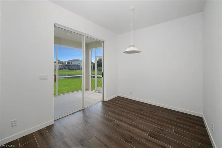 Empty room featuring dark hardwood / wood-style flooring