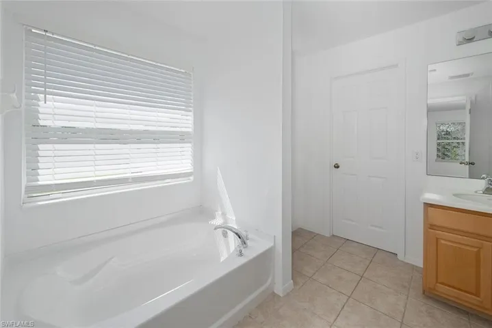 Bathroom featuring vanity, tile patterned floors, and a bathtub