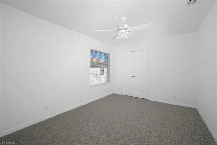 Carpeted spare room featuring ceiling fan