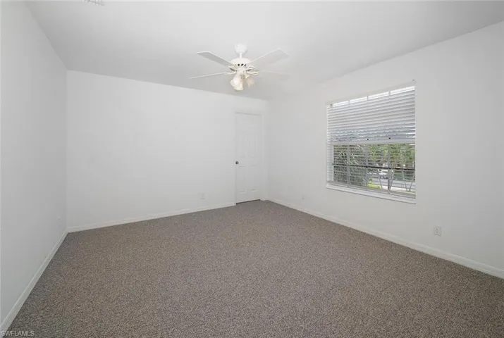 Unfurnished room featuring carpet floors and ceiling fan