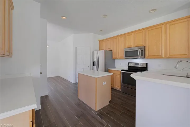 Kitchen featuring a center island, light brown cabinetry, appliances with stainless steel finishes, and sink