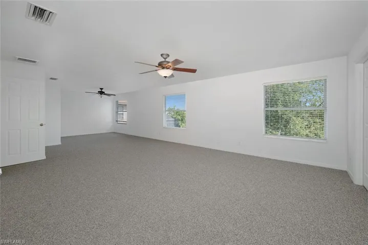 Carpeted spare room featuring ceiling fan