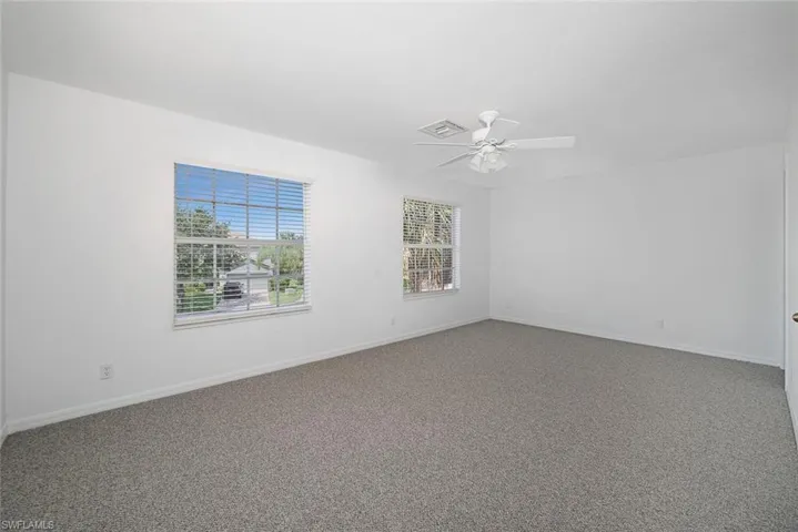 Carpeted empty room featuring ceiling fan
