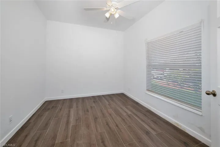 Unfurnished room with ceiling fan and dark hardwood / wood-style floors