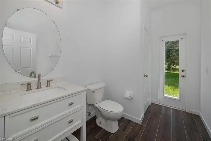 Bathroom featuring hardwood / wood-style floors, vanity, and toilet